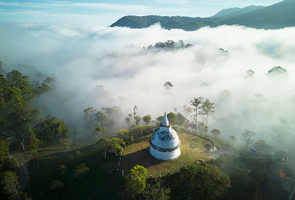 Misty mountain stupa and lush sacred landscape in Sri Lanka